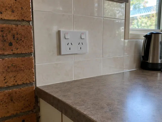Double power point on a tiled kitchen splashback above a benchtop in Tingira Heights